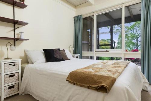 a bedroom with a large bed and a window at Gisborne Peak Winery Short Term Stays in Gisborne