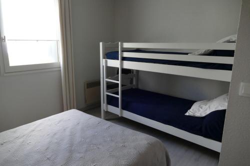 une chambre avec deux lits superposés et une fenêtre dans l'établissement T2 Rez-de-jardin, terrasse et parking, proche de la plage, à La Grande Motte