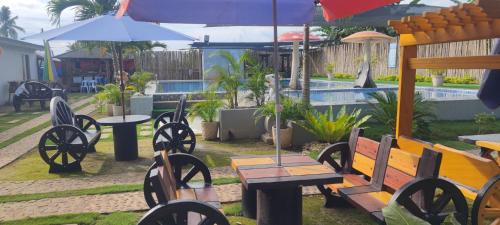 a group of benches and tables with umbrellas and a pool at Little Mouse Resort in San Francisco