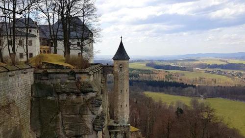 a castle with a tower on top of a hill at ArtHouse Am Kurpark Bad Schandau in Bad Schandau