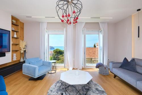 a living room with blue furniture and a large window at New & Stunning Views in Luxury 5* Divona Apartment in Dubrovnik