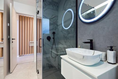 un bagno con un lavandino bianco e uno specchio di New & Stunning Views in Luxury 5* Divona Apartment a Dubrovnik