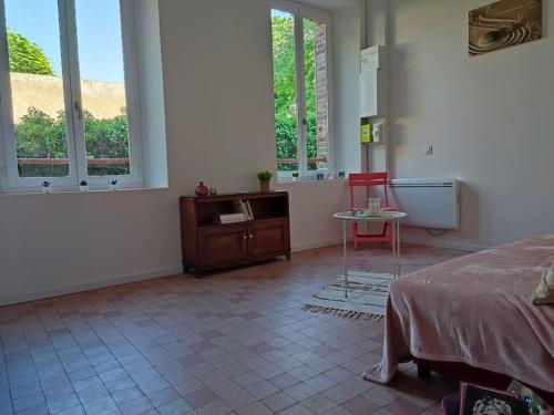 a bedroom with a bed and a table and two chairs at Studio avec une cour. in Joigny