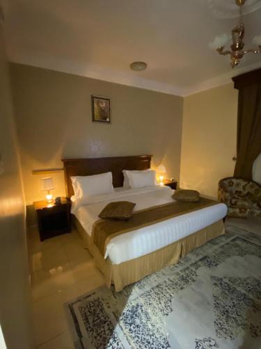 a bedroom with a large bed and a chair at Hayat Redwa Hotel in Yanbu