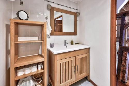 La salle de bains est pourvue d'un lavabo et d'un miroir. dans l'établissement Maison de ville spacieuse et calme en plein coeur d'Amiens, à Amiens