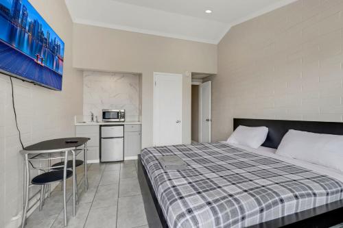 a small bedroom with a bed and a kitchen at Desert Moon Motel in Las Vegas