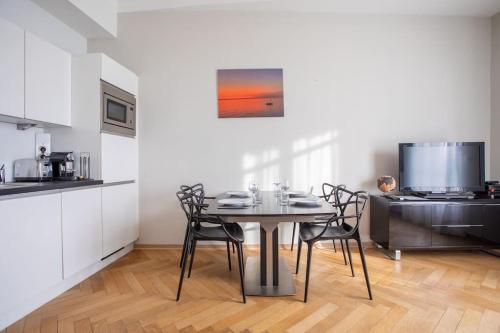 une salle à manger avec une table et des chaises dans une cuisine dans l'établissement 20 LACROI - Superbe appartement 2 chambres avec vue mer centre Cannes, à Cannes