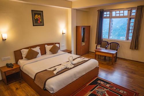 a bedroom with a large bed with a large window at The Loft Norling Hotel & Spa in Bhurtuk