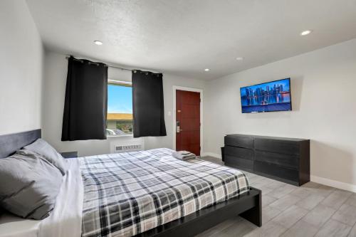 a bedroom with a bed and a tv on the wall at Desert Moon Motel in Las Vegas