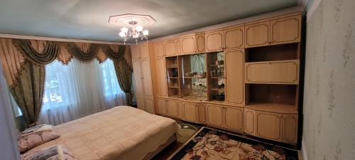 a bedroom with a bed and a large cabinet at Qusarda günlük kiraye əv,Guest house for the rent Shahdag Kusary in Qusar