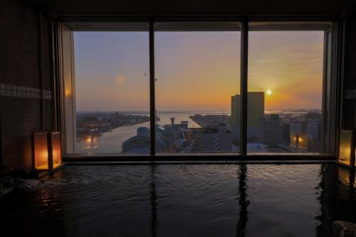 a room with a view of a city from a building at Dormy Inn PREMIUM Kushiro in Kushiro