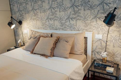 a bedroom with a white bed with blue and white wallpaper at Suite 51 Luxury home in Pescara