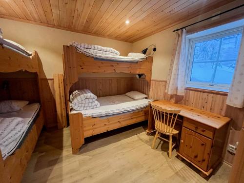 a room with two bunk beds and a desk at Fjällvidden - lyxig fjällstuga i Idre in Idre Fjäll