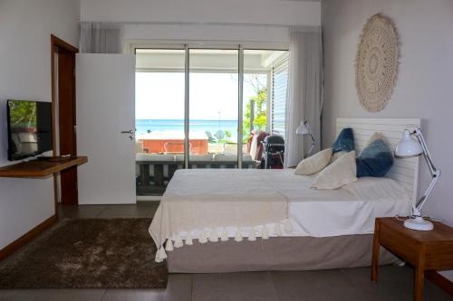a bedroom with a bed and a view of the ocean at O'Biches by Horizon Holidays - Trou aux Biches in Trou aux Biches