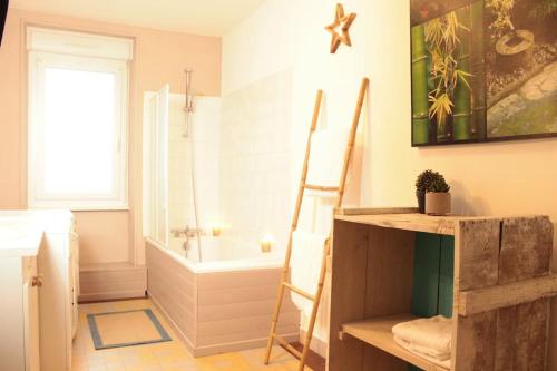 a bathroom with a ladder and a bath tub at L'Aparté - Appartement cosy esprit montagne in Bussang