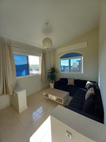 a living room with a blue couch and two windows at Appartment with terrrasse ANDALUCIA Inn Tanger in Tangier