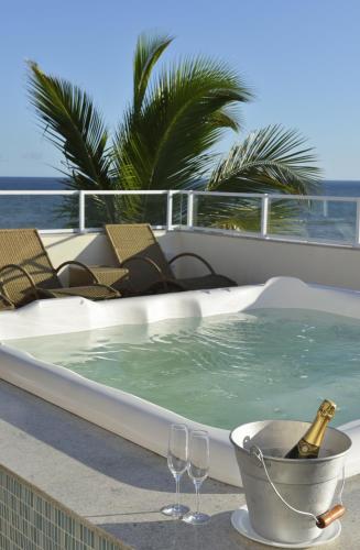 a hot tub with a bottle of champagne and two wine glasses at Rede Andrade Express in Salvador
