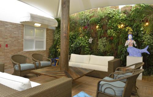 a living room with a wall of plants at Rede Andrade Express in Salvador