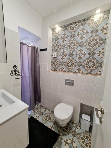 ein Bad mit einem WC und einer Fliesenwand in der Unterkunft Suite4u in Eilat