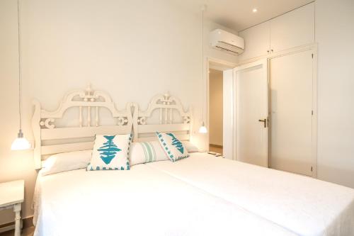 ポルト・ダ・ポリェンサにあるVilla BAMBU Pollensaの白いベッドルーム(青い枕の白いベッド付)