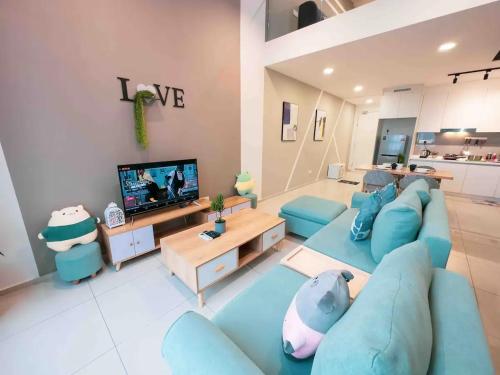 uma sala de estar com um sofá azul e uma televisão em EkoCheras Cozy Suite by GUESTONIC em Kuala Lumpur
