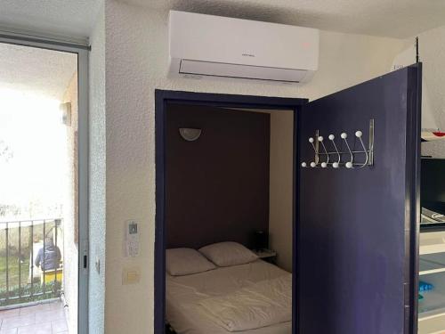 une petite chambre avec un lit dans une pièce dans l'établissement appartement le Florid Cap d'Agde, T2 , 4 pers, 200m plage, terrasse, au Cap d'Agde
