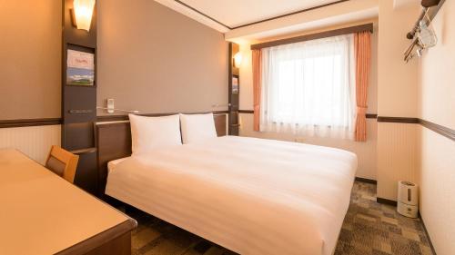 Postel nebo postele na pokoji v ubytování Toyoko Inn Tokyo Tachikawa eki Kita guchi