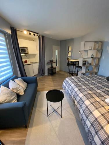 uma sala de estar com um sofá azul e uma cama em Les terrasses de Port Nabat 2 em Vannes