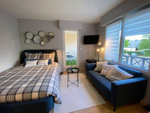 um quarto com uma cama e um sofá em Les terrasses de Port Nabat 2 em Vannes