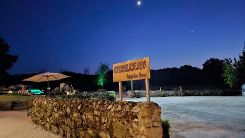 a sign sitting in front of a stone wall at Loft con Jacuzzi os Arcos in Sober