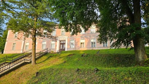 a large building on top of a hill with trees at Black M - Penzión - Reštaurácia in Banská Štiavnica