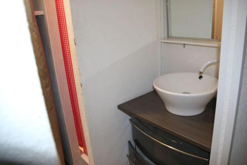 une salle de bain avec un lavabo blanc et un miroir dans l'établissement Studio 659, Port Nature 6 au village naturiste, au Cap d'Agde