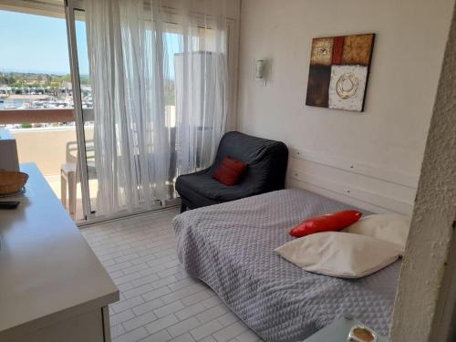 une chambre avec un lit, une chaise et une fenêtre dans l'établissement Studio 659, Port Nature 6 au village naturiste, au Cap d'Agde