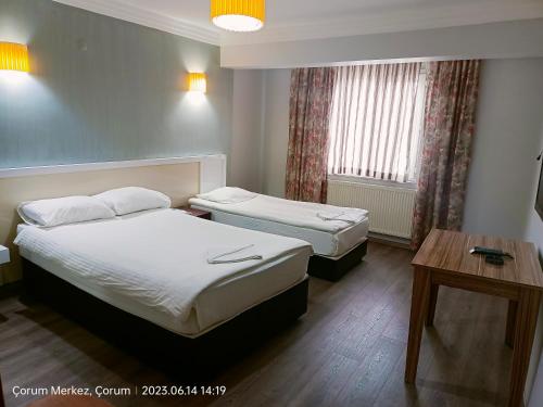 a hotel room with two beds and a table at Şirin Apart in Corum