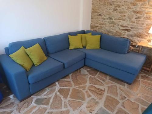 a blue couch with yellow pillows in a living room at Frantato Seaview in Akamatra