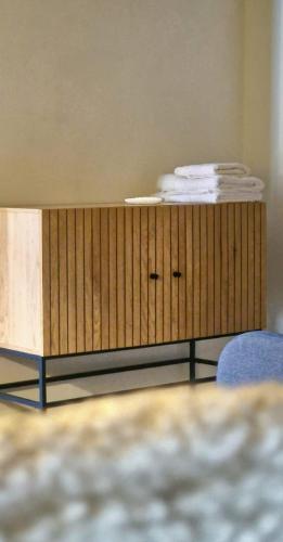 a wooden cabinet in a room with a blue chair at Aveiro Sweet Nest in Aveiro