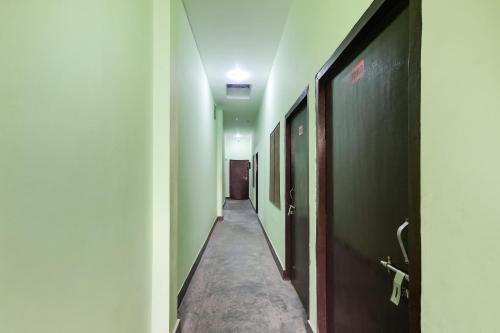 um corredor com paredes verdes e um longo corredor em Relax Inn Hotel em Lucknow