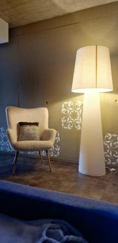 a room with a chair and a lamp and a chair at Aveiro Sweet Nest in Aveiro