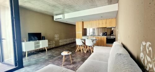 a living room with a couch and a kitchen at Aveiro Sweet Nest in Aveiro