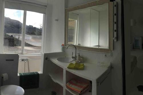 a bathroom with a sink and a mirror and a window at Studio III at orig. Finca,, sea views in La Asomada