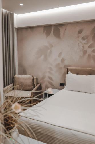 a bedroom with a bed and two chairs at Hotel Oasis in Sarandë