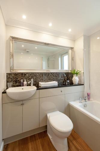 a bathroom with a sink and a toilet and a mirror at Gilmour's Entry Apartment in Edinburgh