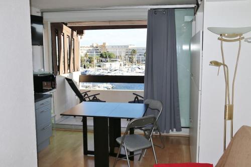 Cette chambre dispose d'un balcon avec une table et des chaises. dans l'établissement Studio 407, Port Vénus au village naturiste, au Cap d'Agde