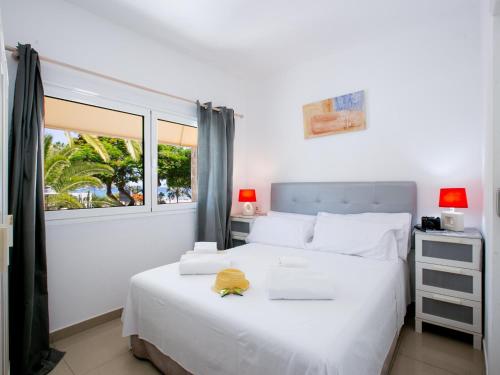 ein Schlafzimmer mit einem großen weißen Bett und einem Fenster in der Unterkunft Casa Peter Los Cristianos in Los Cristianos