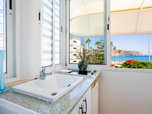a bathroom with a sink and two windows at Casa Peter Los Cristianos in Los Cristianos
