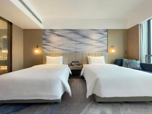 Una cama o camas en una habitación de White Swan VYV Hotel, Foshan