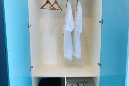 a white robe hanging on a rack in a closet at Kampot Sunny Hotel in Kampot