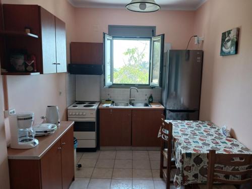 a small kitchen with a sink and a refrigerator at Reggina's place in Kefallonia