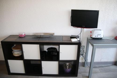 - une télévision assise au-dessus d'une table dans l'établissement Studio 646, Port Nature 6 au village naturiste, au Cap d'Agde