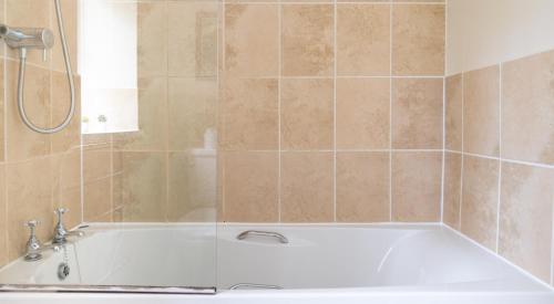 a bathroom with a white tub and a shower at Bibby Lot in Rusland